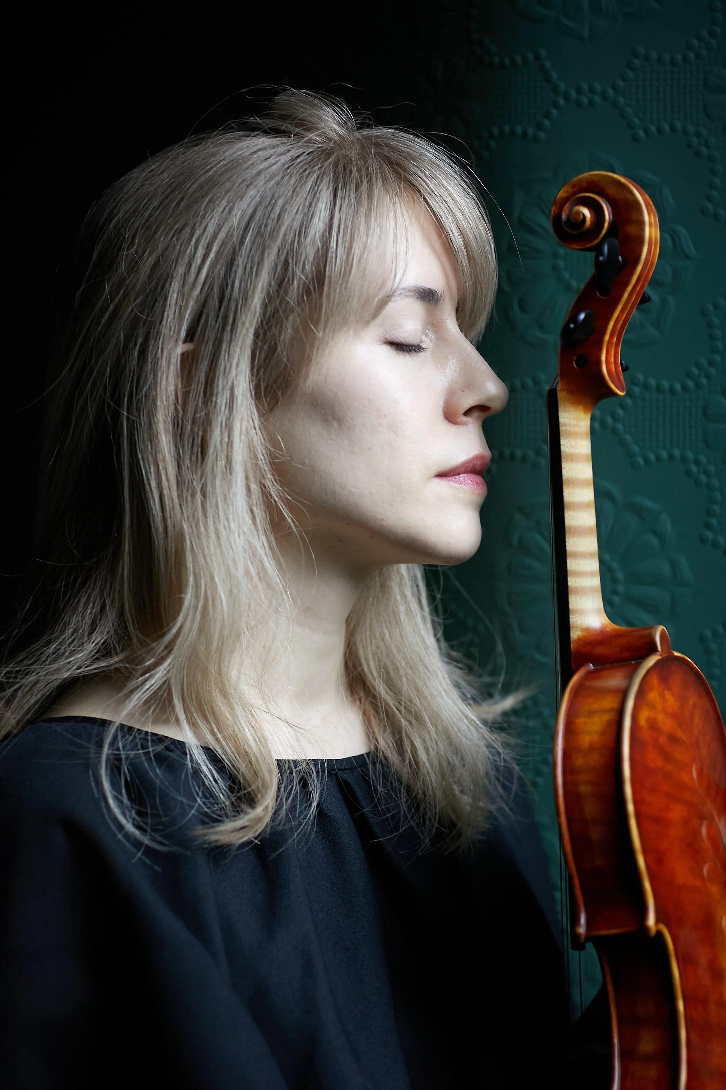Side profile of Talia Ramos violinist holding her violin