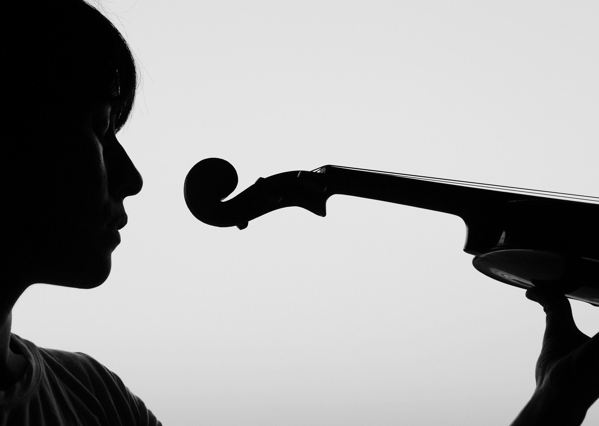 Black and white side profile of violinist Talia Ramos holding her violin