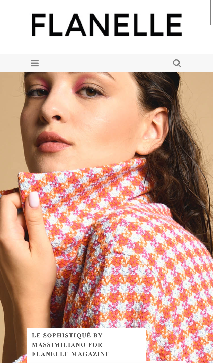 Pagina web di Flanelle magazine con immagine di una donna con trucco leggero, vestita con un maglione in tessuto a quadri arancio, rosa e bianco.