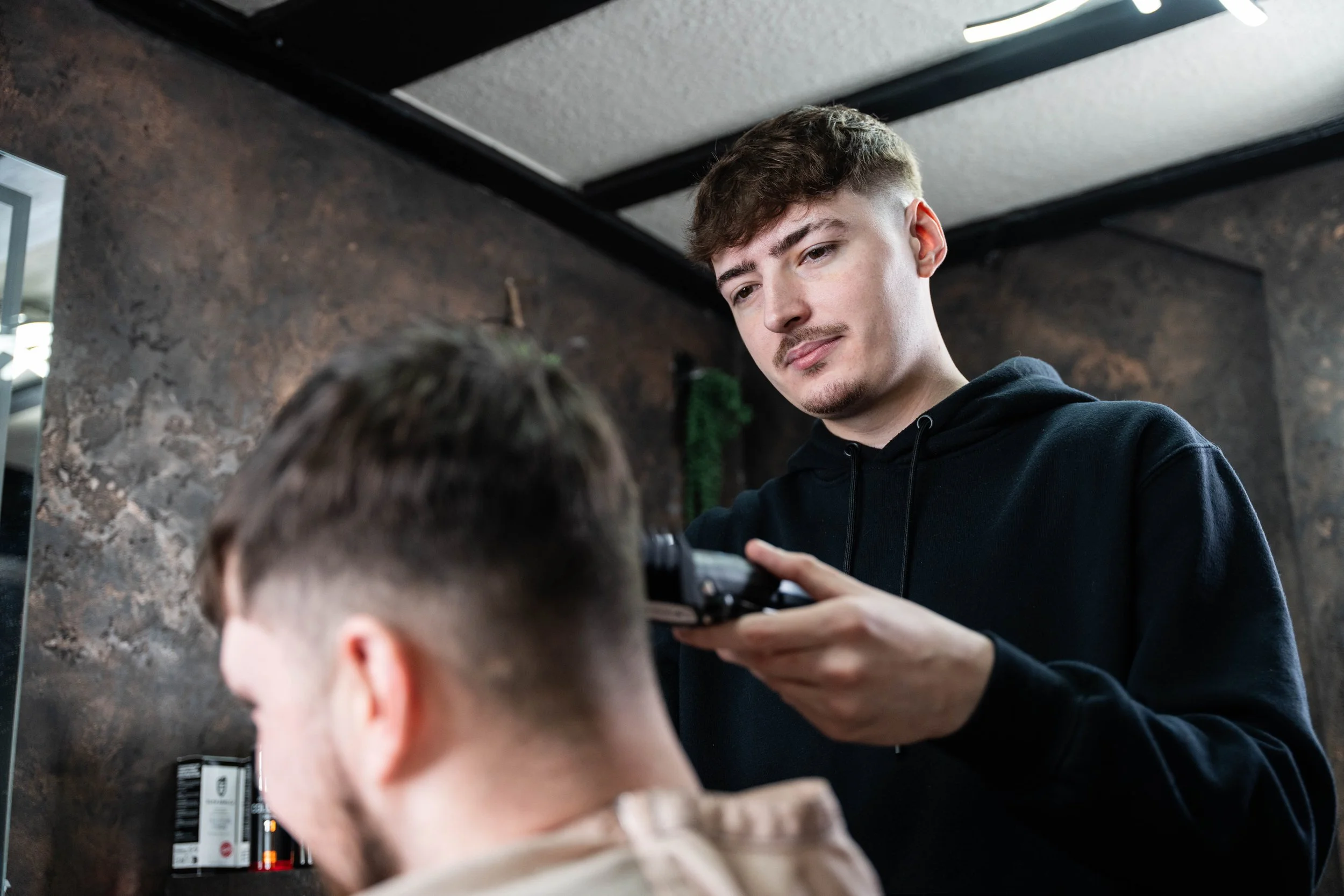 Barber giving a haircut to a customer in a modern salon.