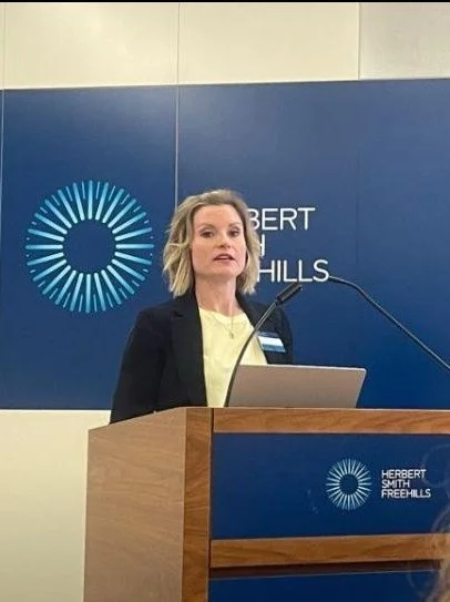 A photo of Lucy Wood speaking at a podium.