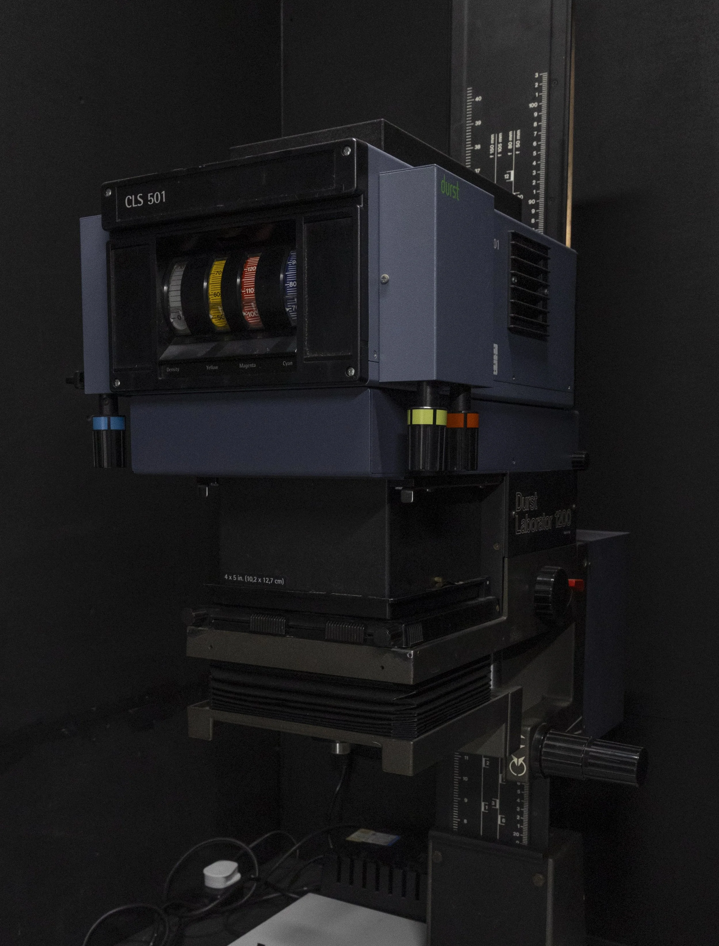Close-up of a color calibration device with colored dials and a scale on the side, mounted on a laboratory instrument called a Durst Laborator 1250.