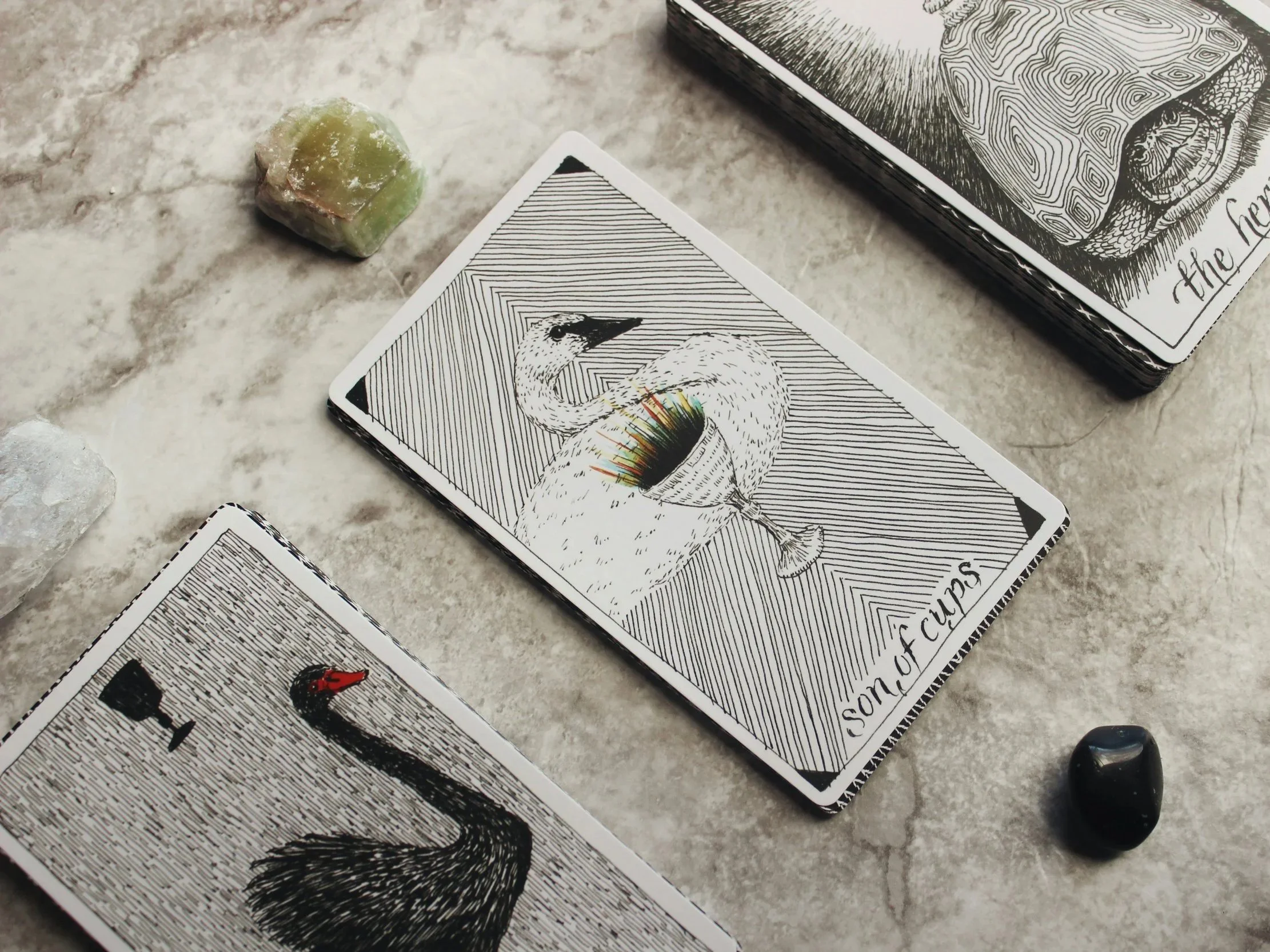 Cartas del tarot y piedras decorativas sobre una superficie de tierra.