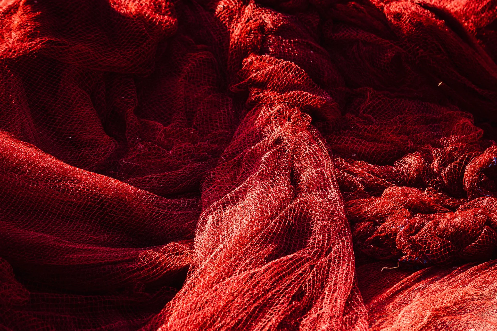 Close-up of red mesh fabric with intricate folds and texture.
