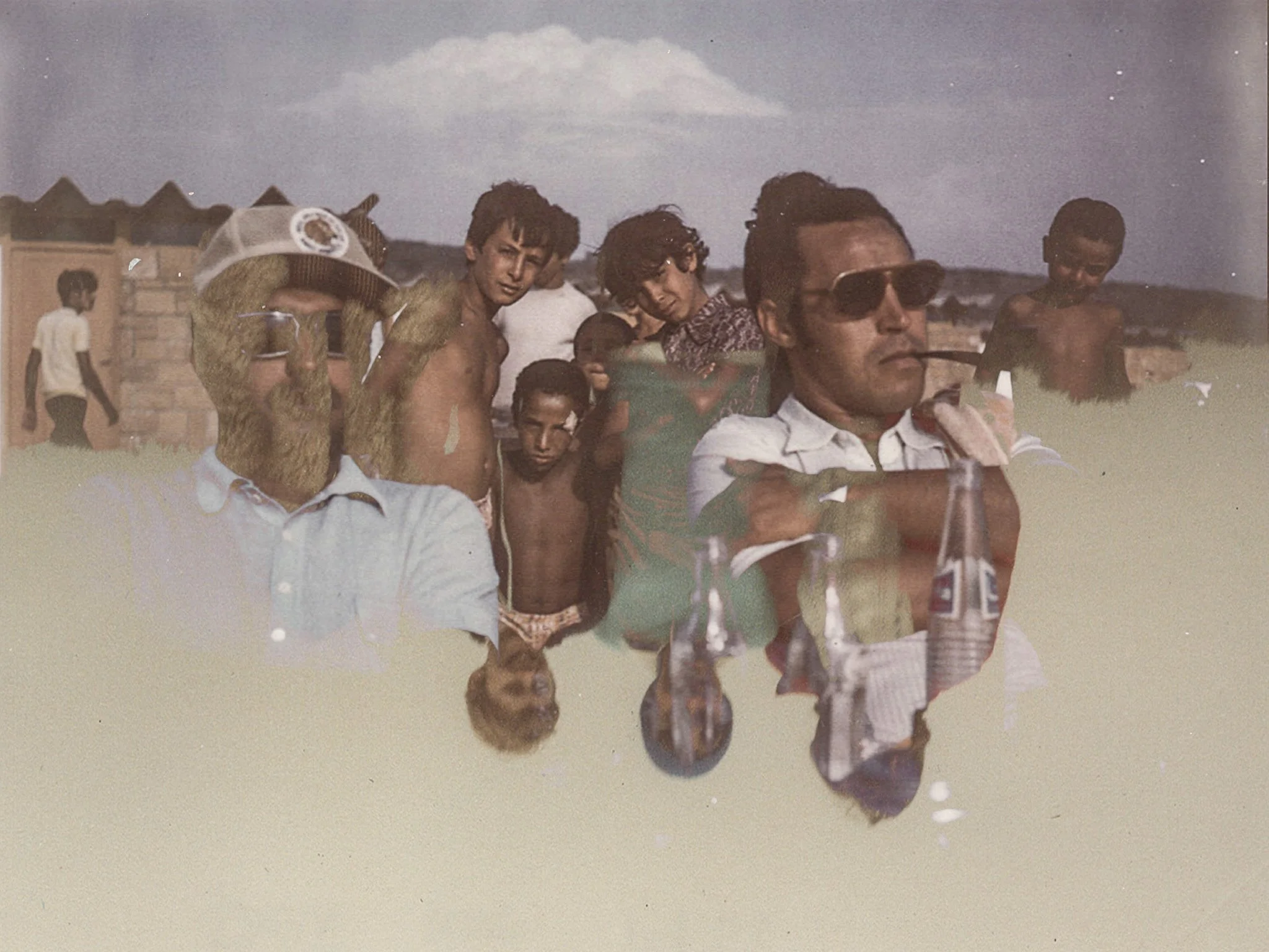 A vintage photo of a group of men standing outdoors, some shirtless, with buildings in the background, during daytime.