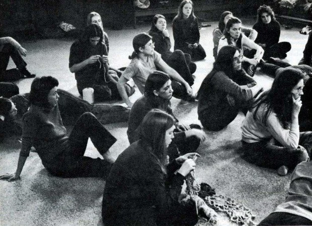 Group of women sitting on the floor in a circle in a room.