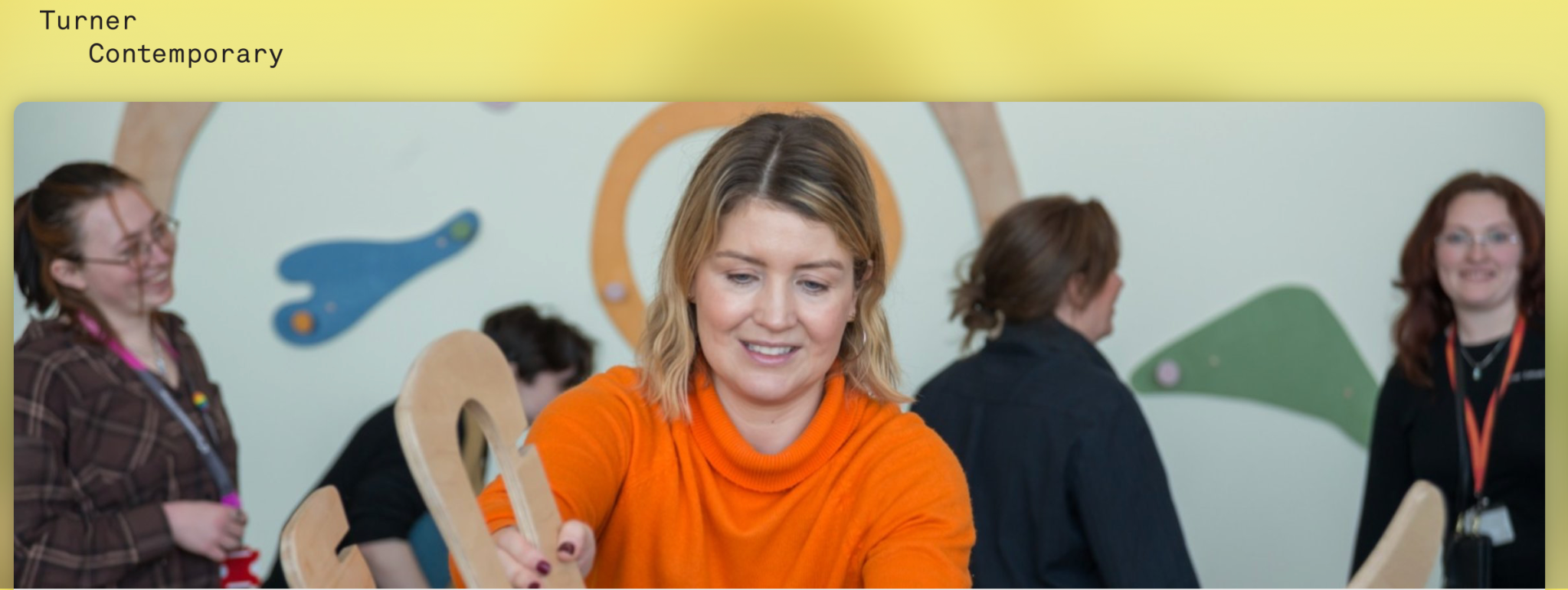 Women participating in a workshop or event at Turner Contemporary, with colorful abstract wall art in the background.