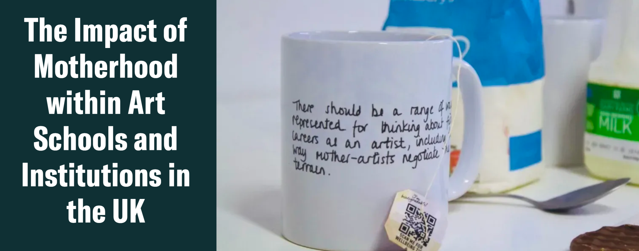 A white ceramic mug with handwritten text about motherhood and art, surrounded by other objects including a carton of milk, a spoon, and a blue container.