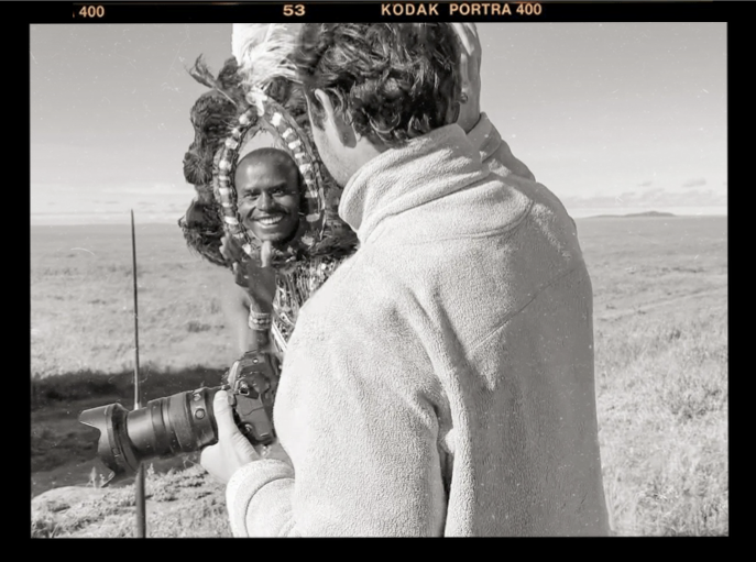 James Lewin and a maasai warrior high five after a successful photoshoot