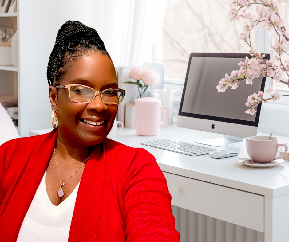 Echo Marie Bryant smiling in a bright home office with a white desk, pink flower vase, pink coffee mug, and an iMac computer.