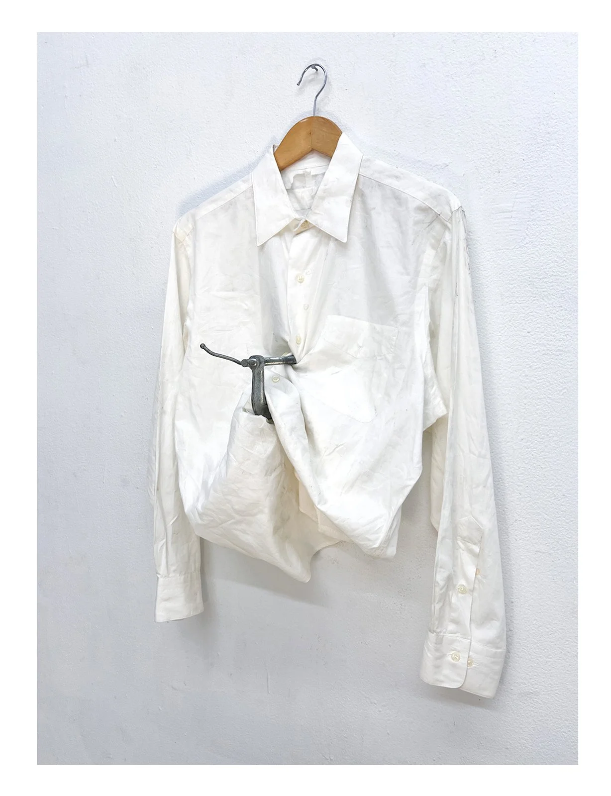 Pressure, white button-down shirt, wooden hanger, metal clamp, 2025