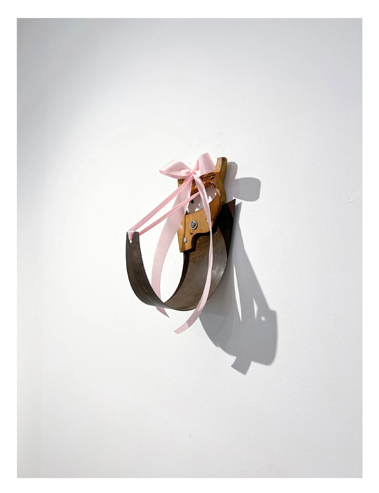 "Bend", Metal and wood saw, satin ribbon, 11.7in x 5.8in x 10.3in