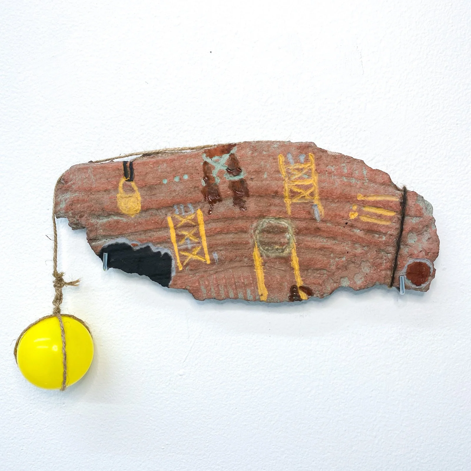 "Love Letter to Scaffolind", earth pigment and walnut oil, cement, twine, plastic ball, 11.7in x 8.4in