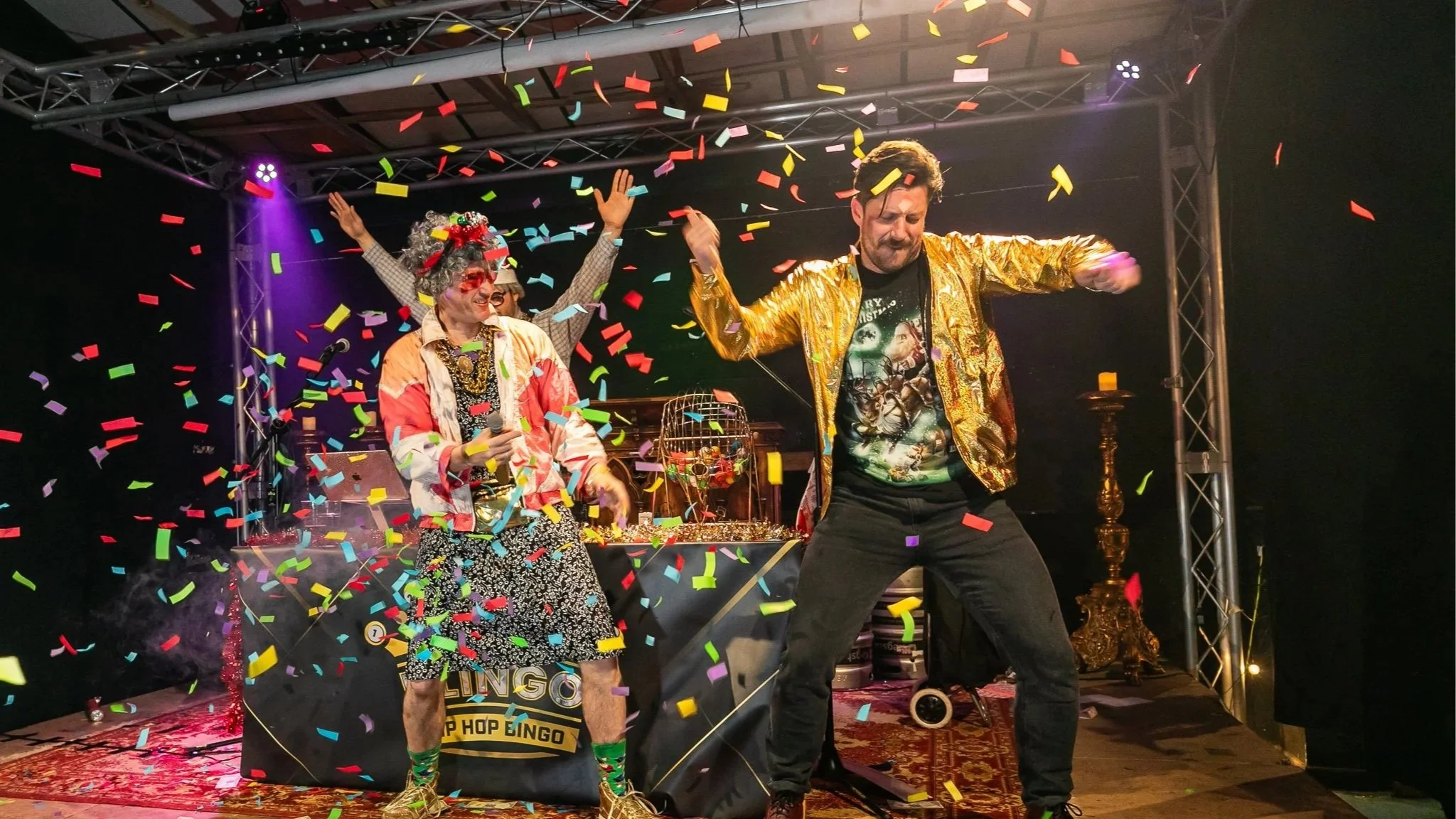 People celebrating winning bingo with confetti on stage, dancing and smiling, in a lively party or entertainment event.