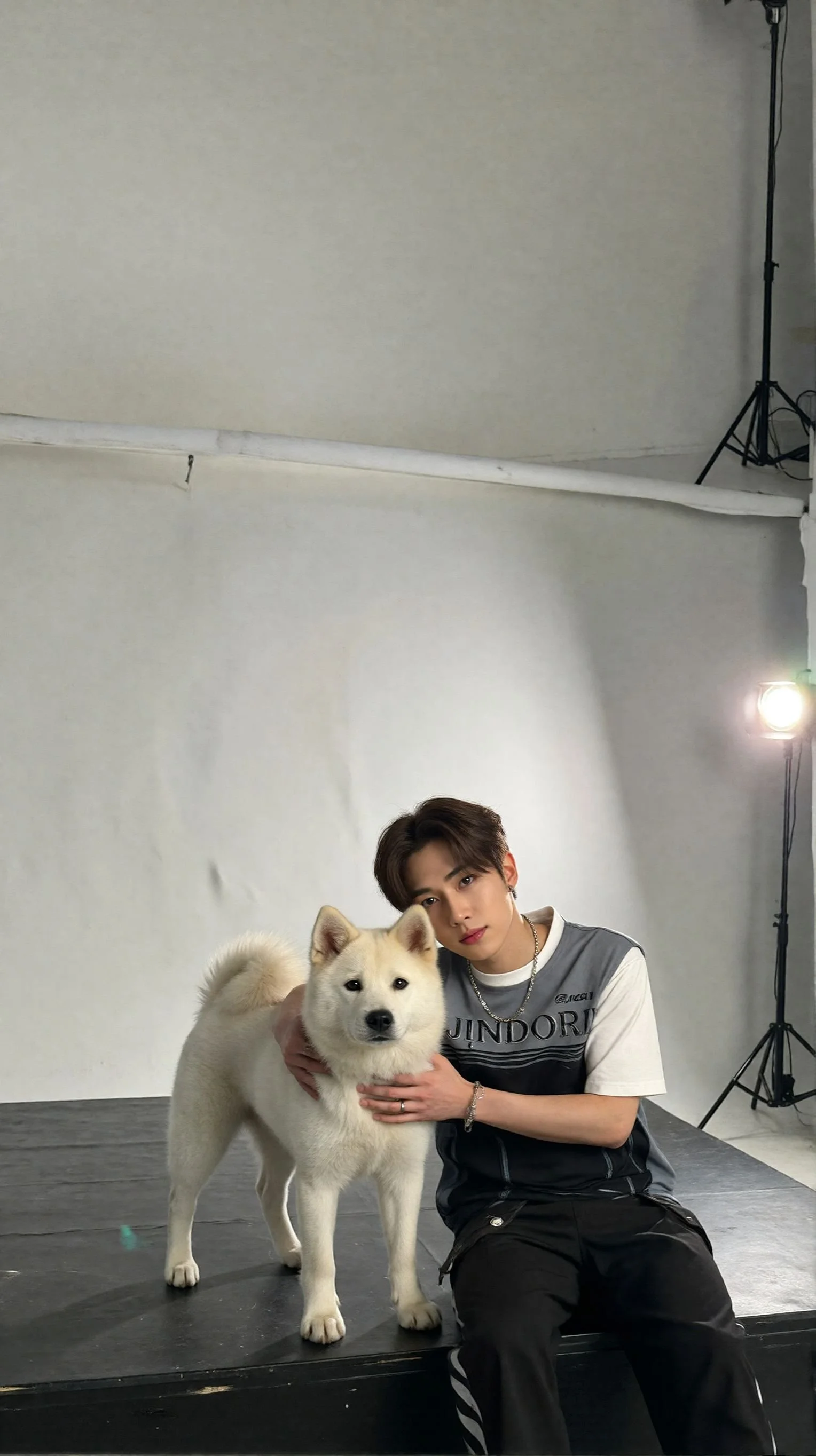 스튜디오에서 모델과 강아지가 포즈를 취하고 있다.