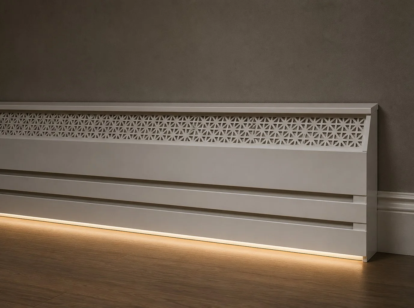 White radiator cover with decorative lattice pattern, located against a gray wall, illuminated by warm floor lighting.