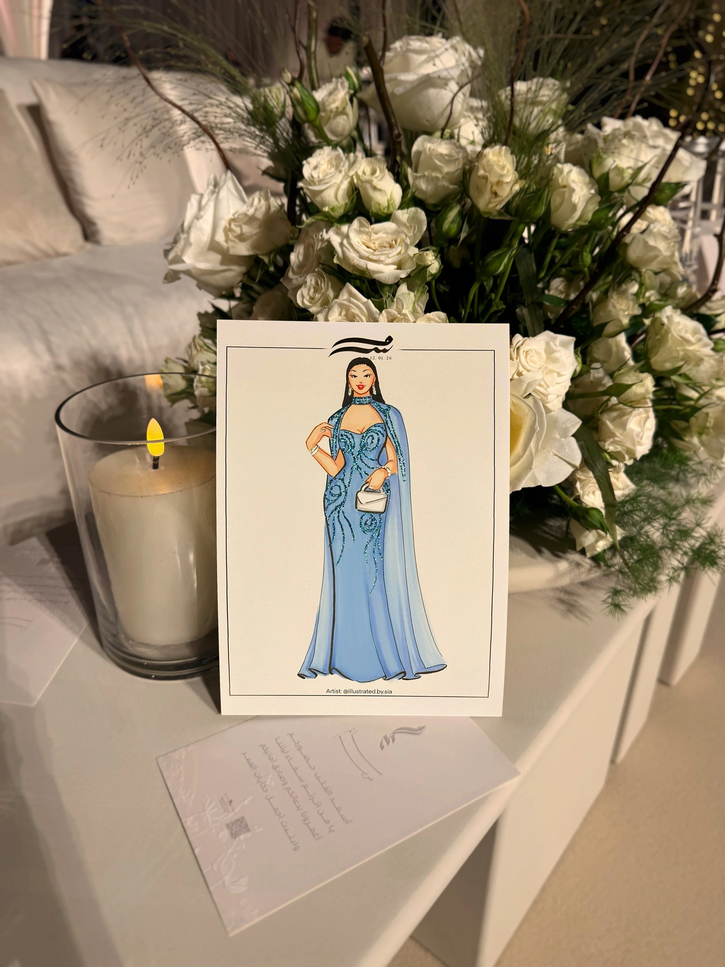 An illustration of a woman in a blue gown. The scene appears to be set on a white surface, possibly at a memorial or special event.