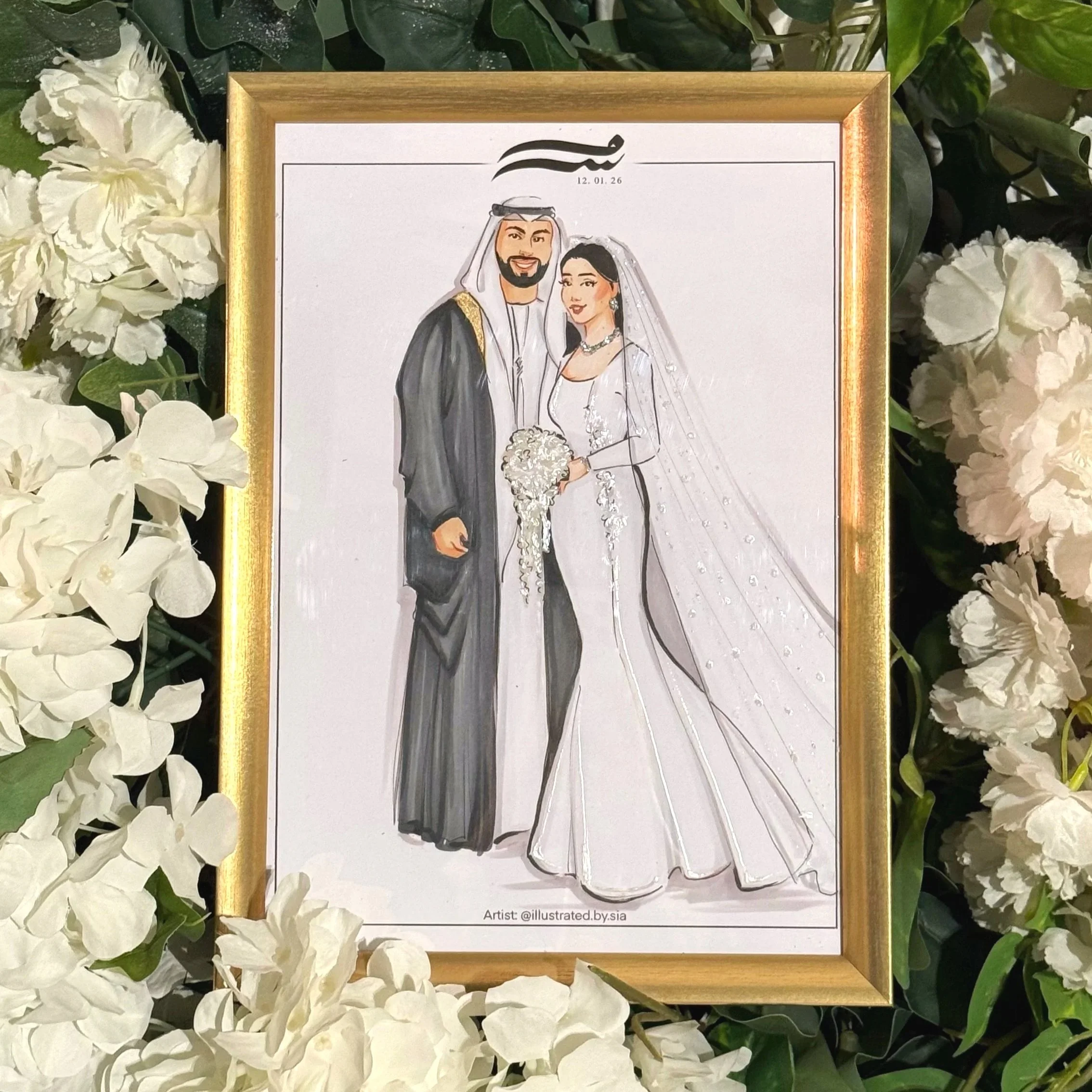 A framed illustrated portrait of a bride and groom surrounded by white flowers and green foliage