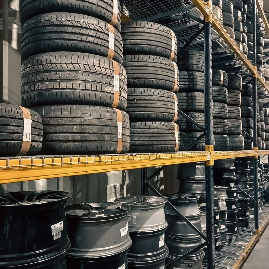 Stacks of black car tires on metal warehouse shelves at Synetiq warehouse in Doncaster.