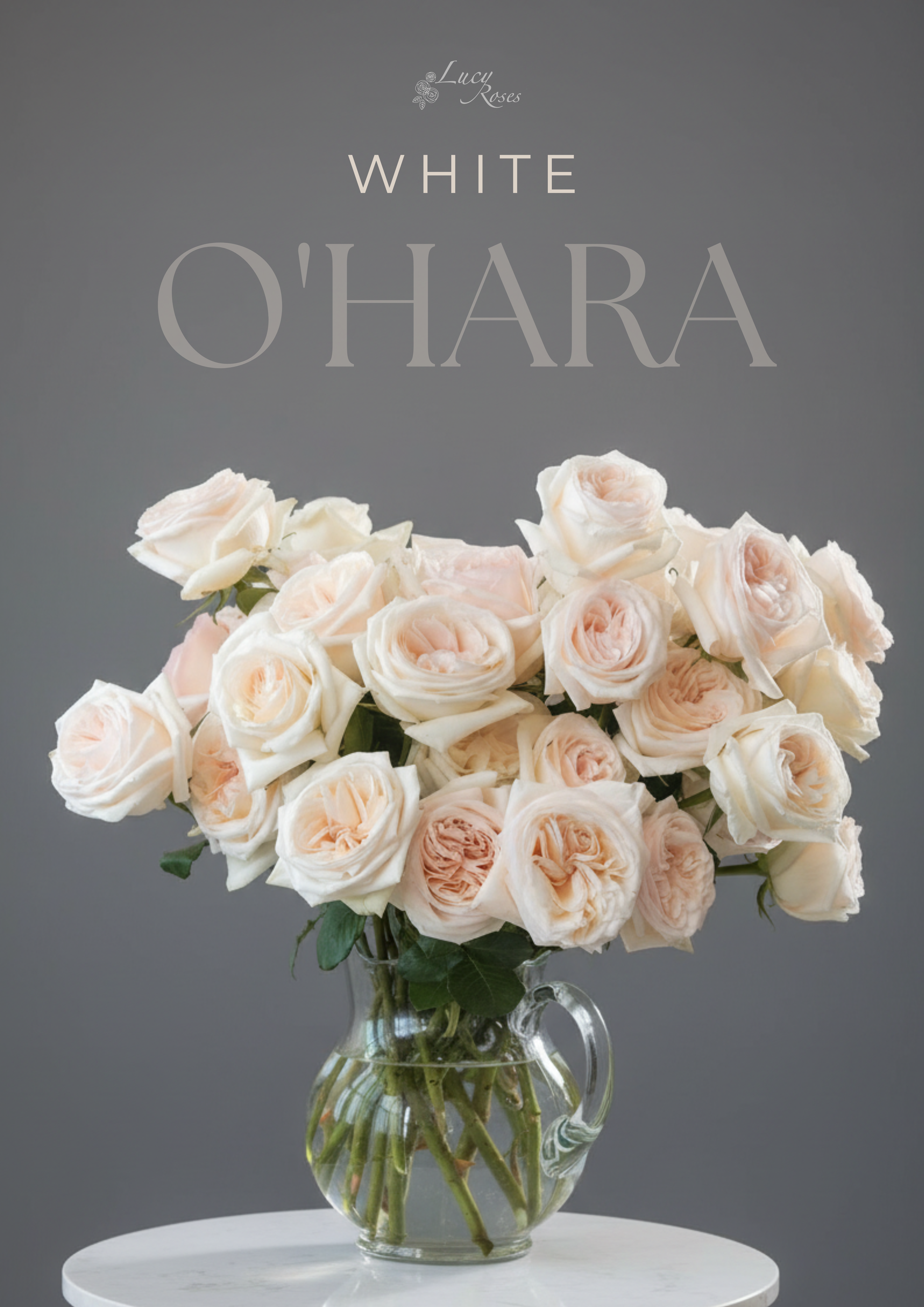 A bouquet of white Ohara and pale pink roses in a glass vase on a white table against a grey background.