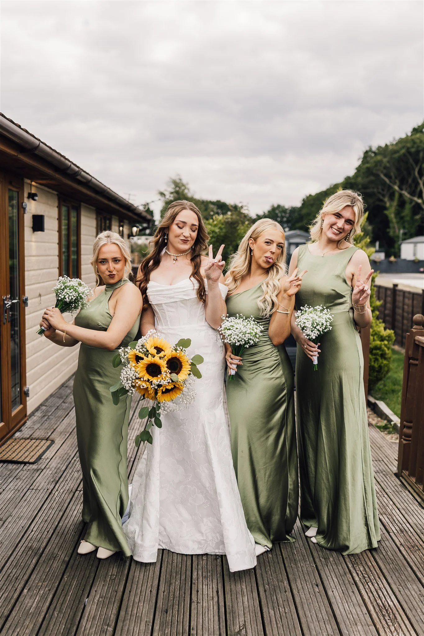 Bride with bridesmaids posing with peace sign