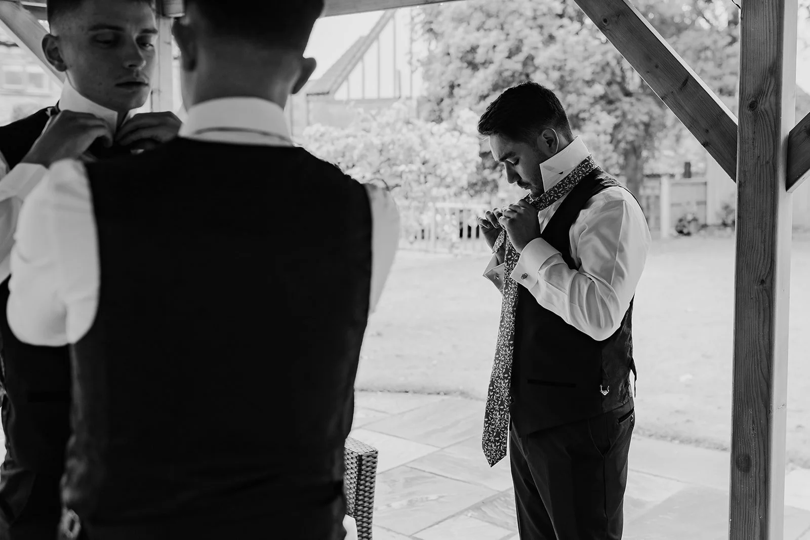Black and white photograph of Rory getting ready beside a window