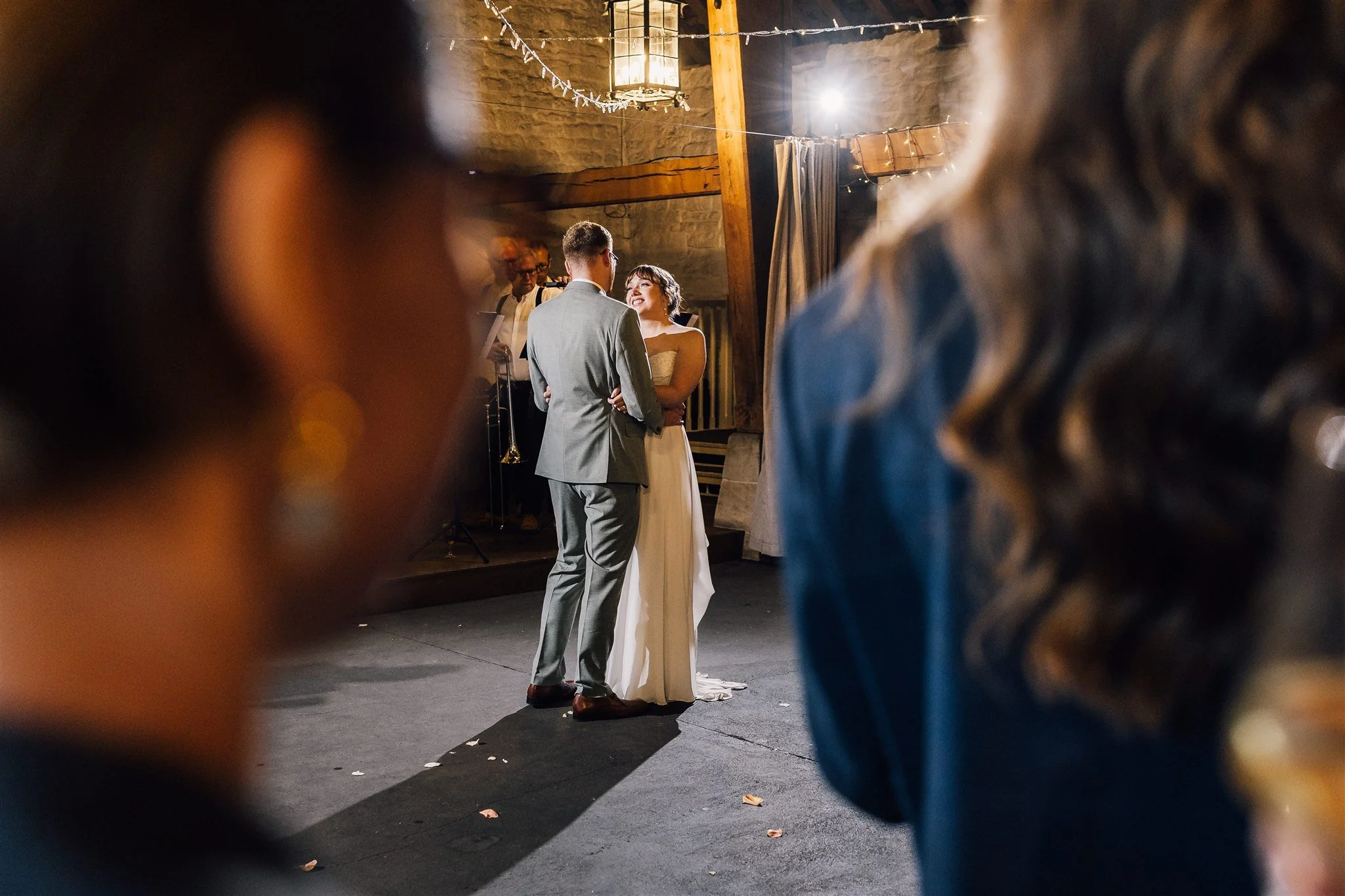 Bride and groom first dance at East Riddlesden Hall captured through guests in foreground