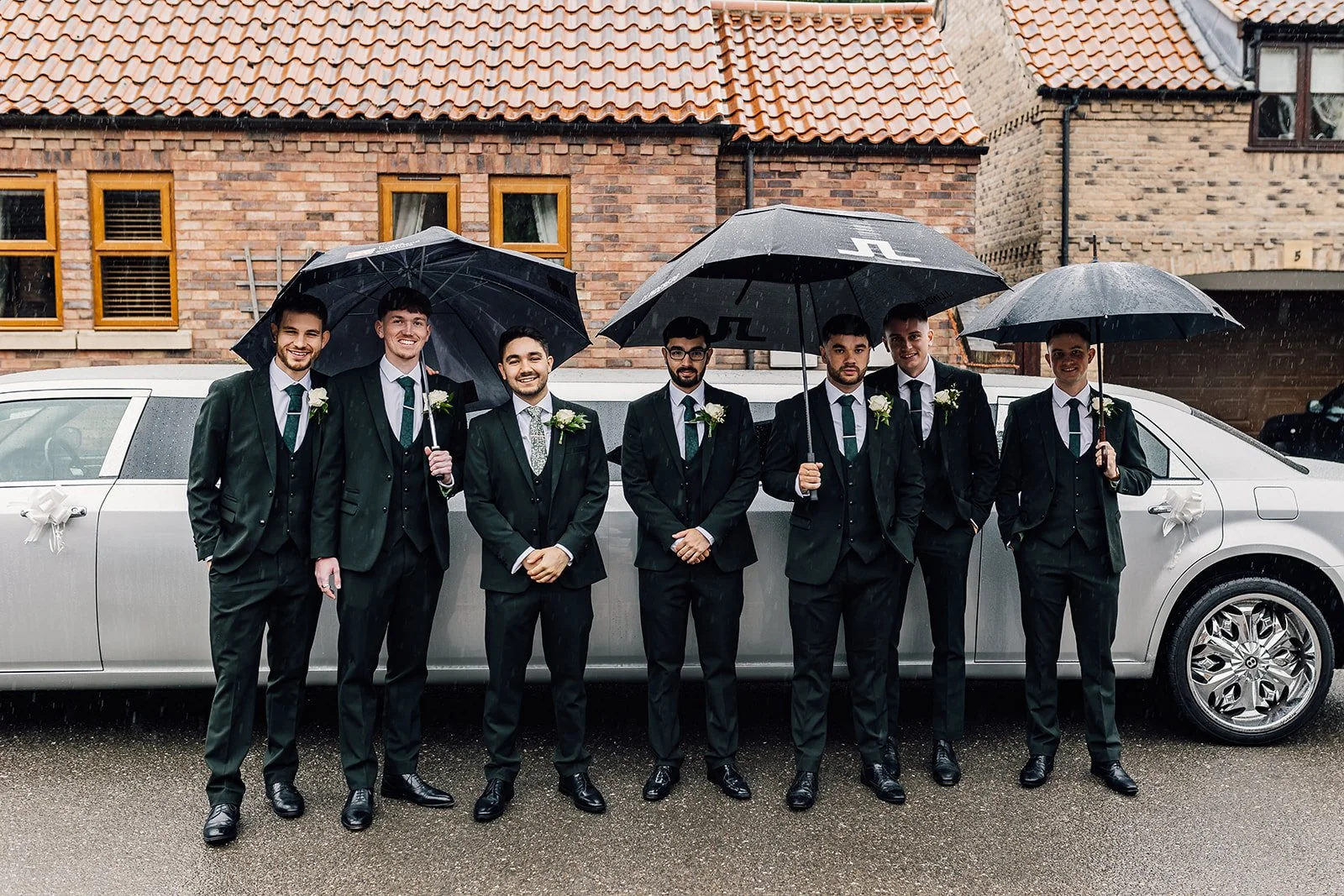 Rory and his groomsmen outside with umbrellas before the wedding