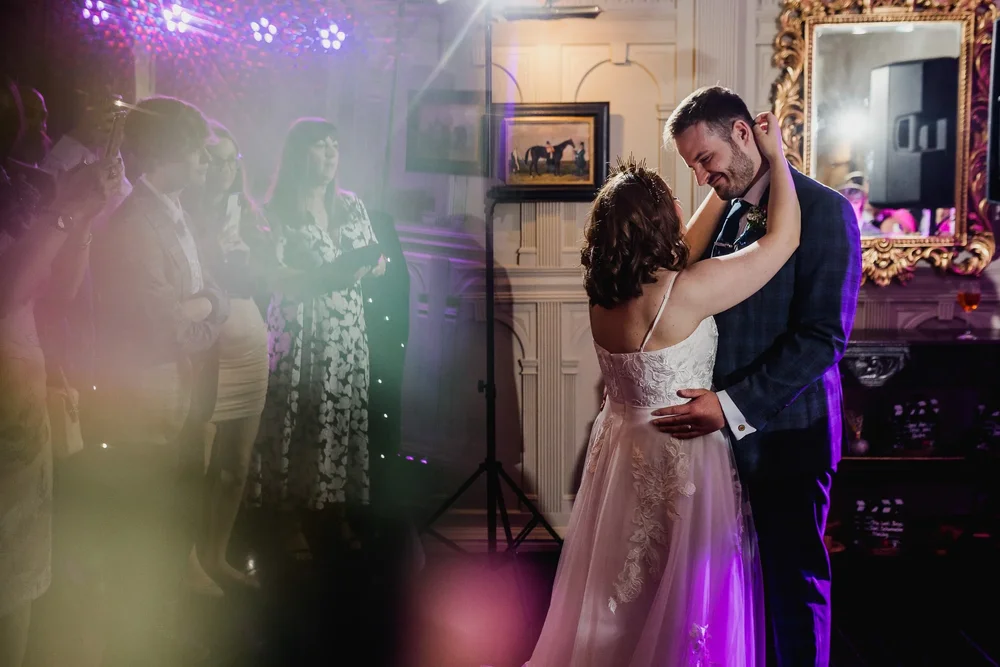 Zach and Katie sharing their first dance in colourful evening light at Highfield House