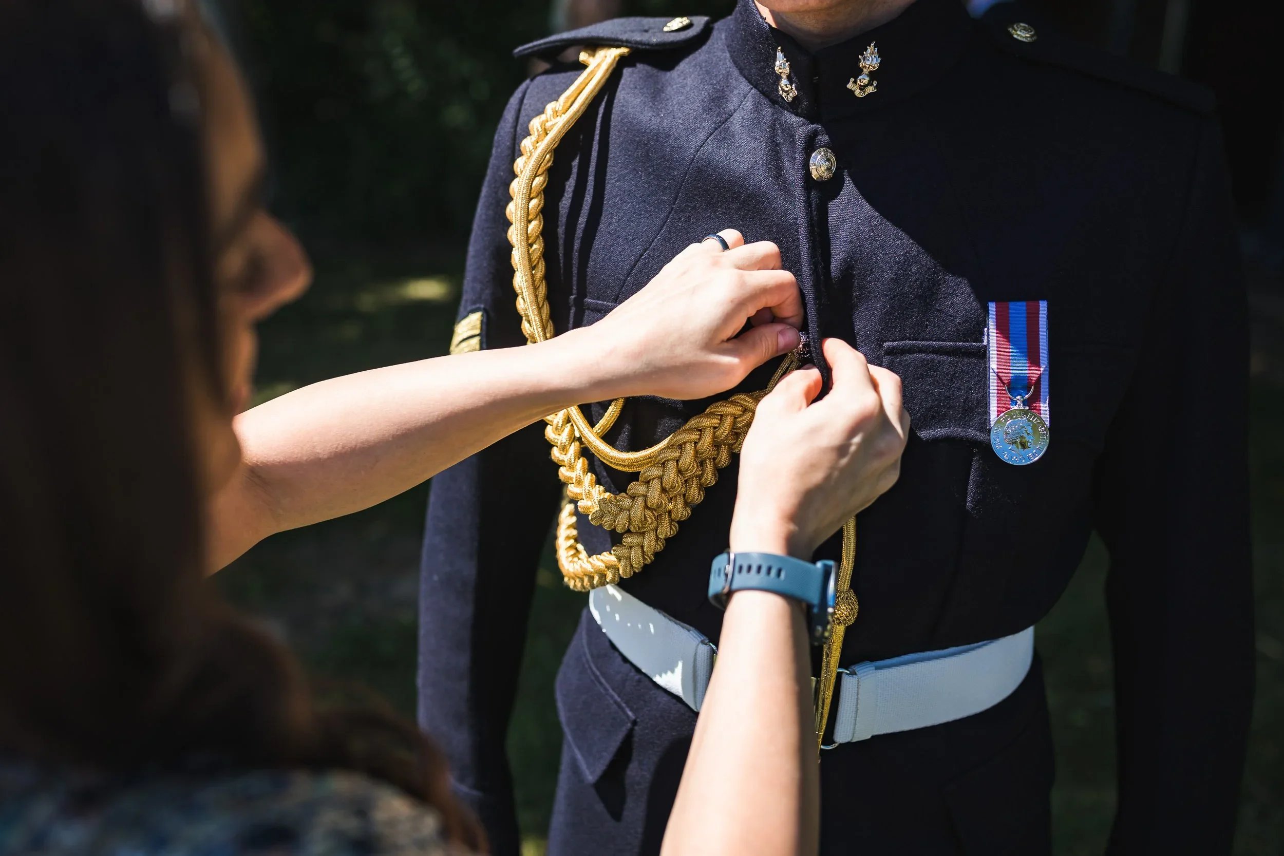 Close up of groom’s military uniform being adjusted before the ceremony at Oaklands Grand Lodge wedding venue in Driffield