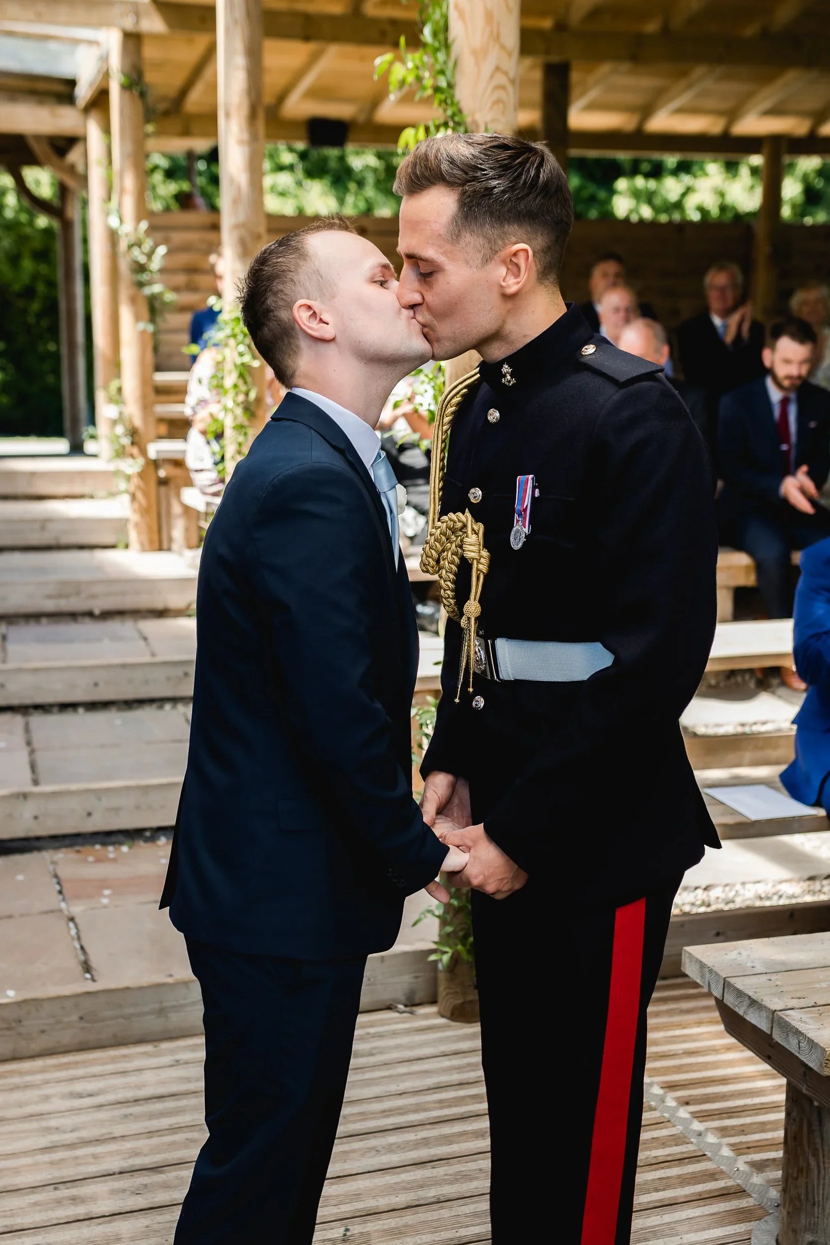 First kiss during Lewis and Guy’s wedding ceremony at Oaklands Grand Lodge lakeside pavilion in Driffield, East Yorkshire.