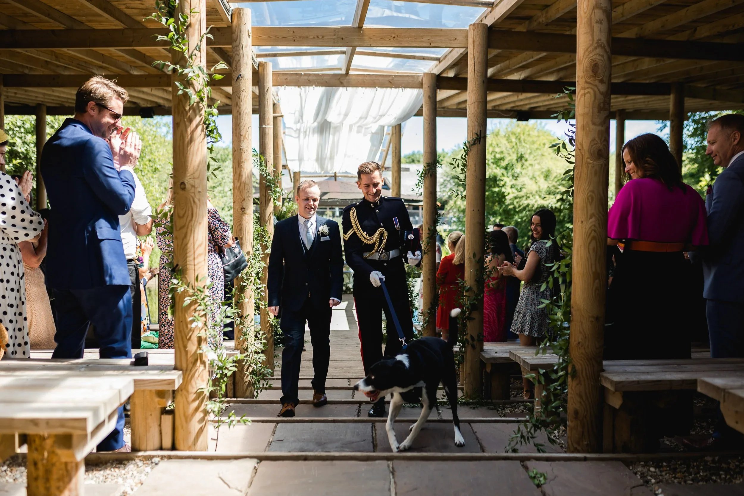 Same sex couple leaving their ceremony with their dog at Oaklands Grand Lodge lakeside pavilion in Driffield.