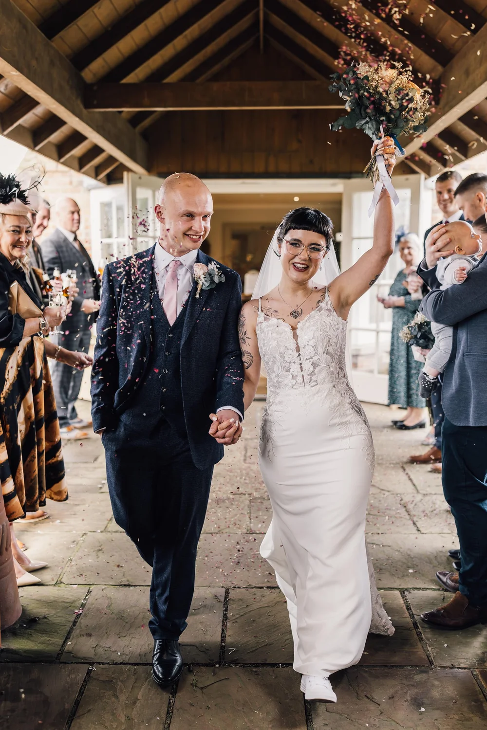 Lucy and Jack leaving their ceremony at Tickton Grange beneath a shower of confetti