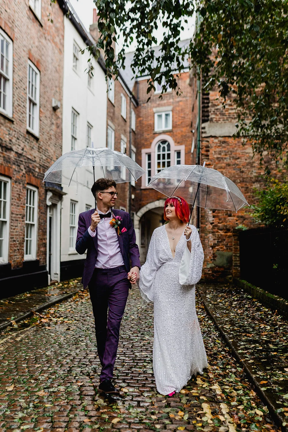 Couple walking through cobbled streets in Hull city centre after their wedding ceremony