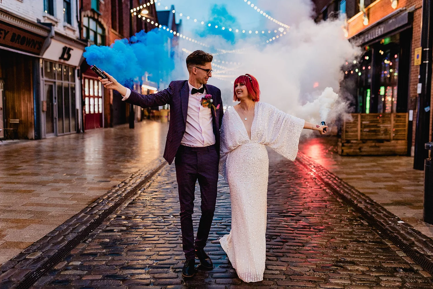 Amy and Callum walking along Humber Street with colourful smoke