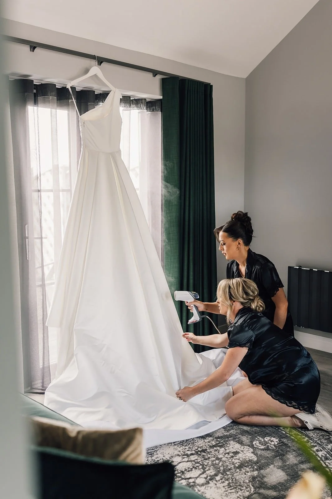 Becky’s wedding dress hanging by the window during preparations at The Barn at Willerby