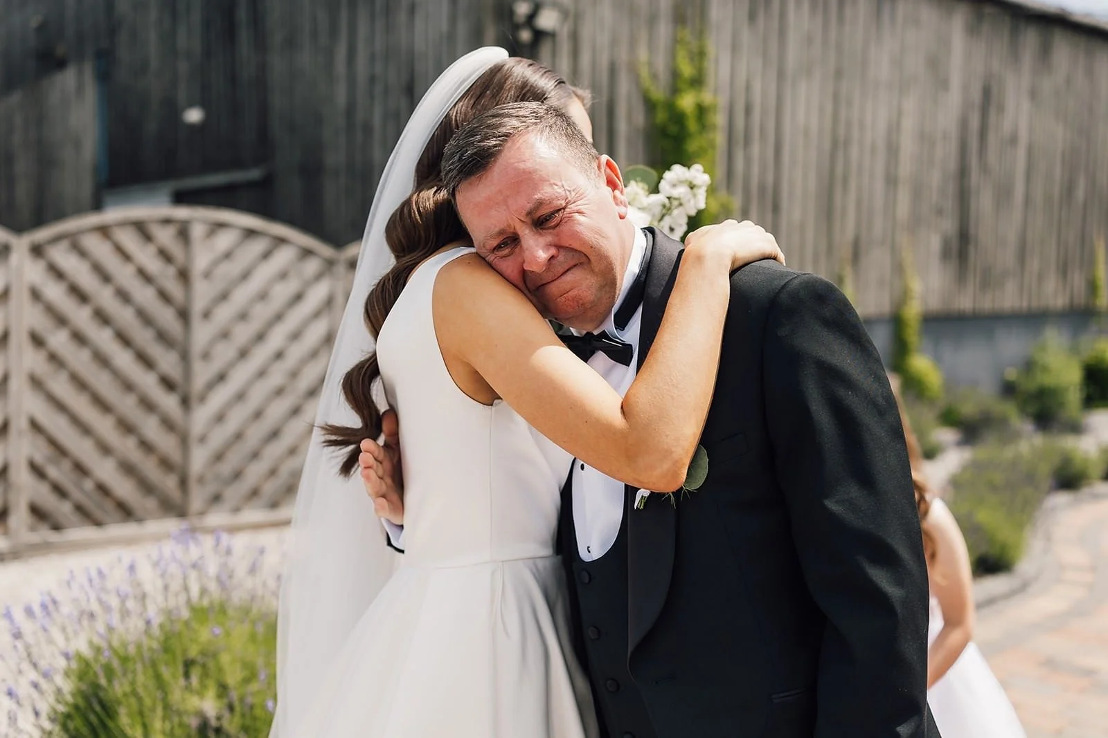 Becky smiling in her one-shoulder wedding dress, photographed in black and white