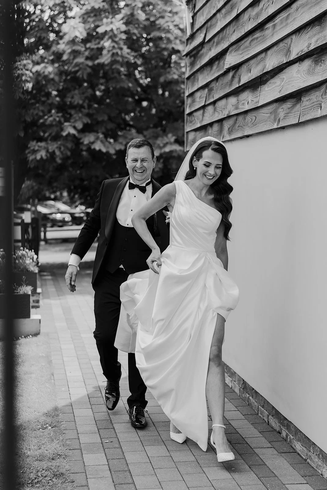 Becky and her bridesmaids carrying her dress through the courtyard at The Barn at Willerby