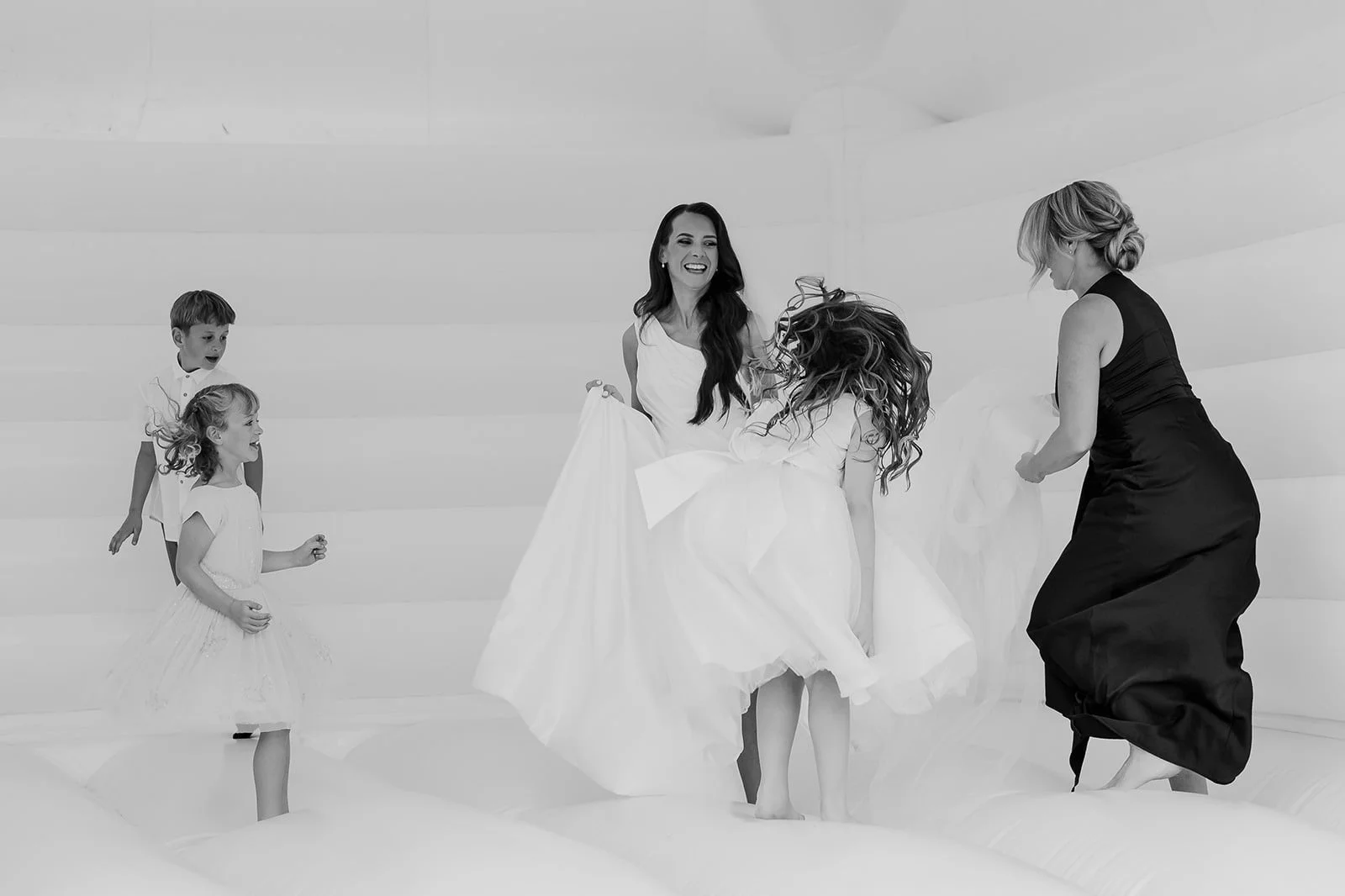 Becky and the children laughing together on the white wedding bouncy castle