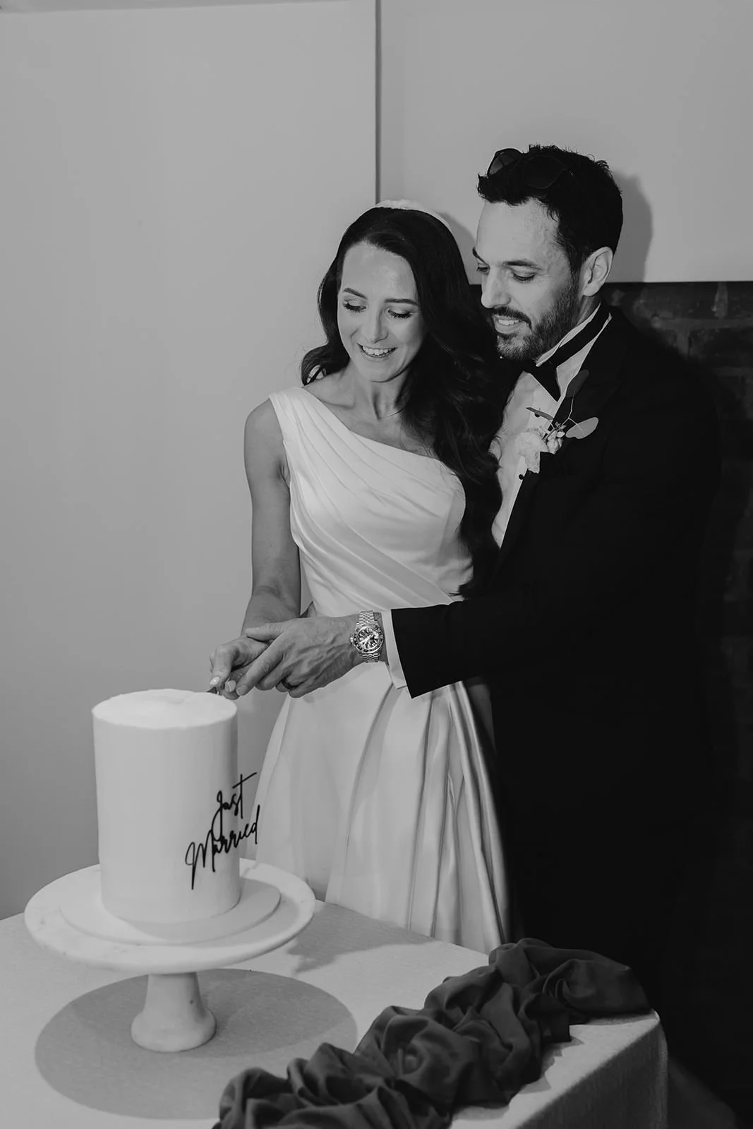 Becky and Brad cutting their wedding cake, photographed in black and white