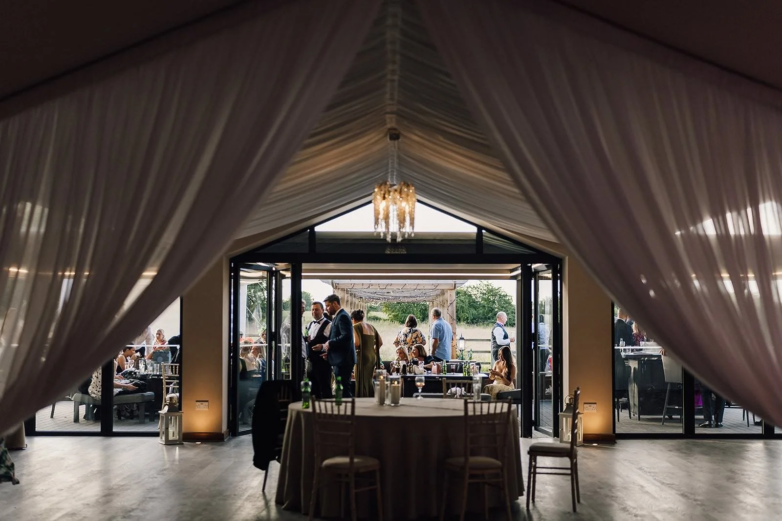 The wedding breakfast room at The Barn at Willerby with draped fabric and fairy lights