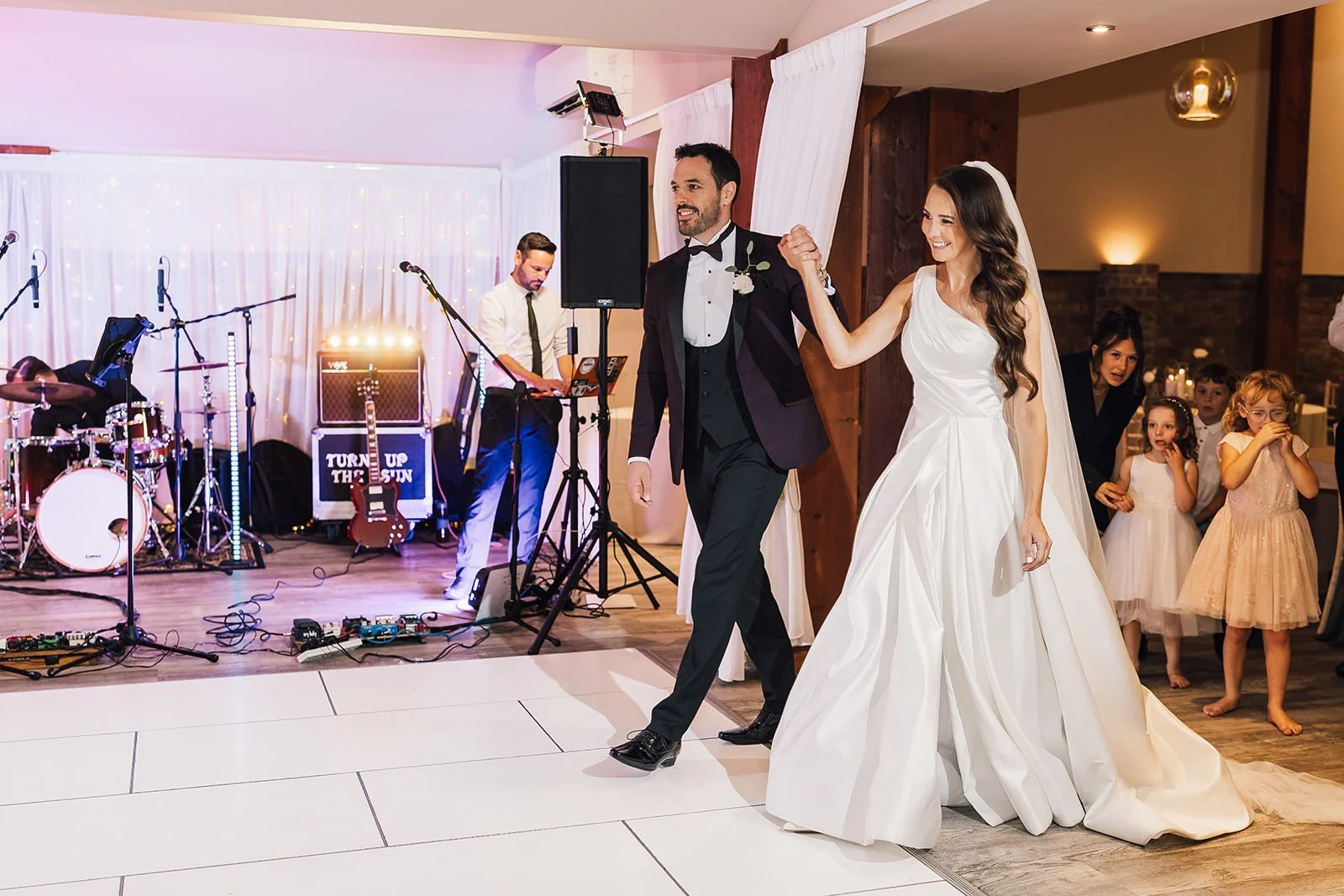 Becky and Brad entering the dance floor in front of the live band
