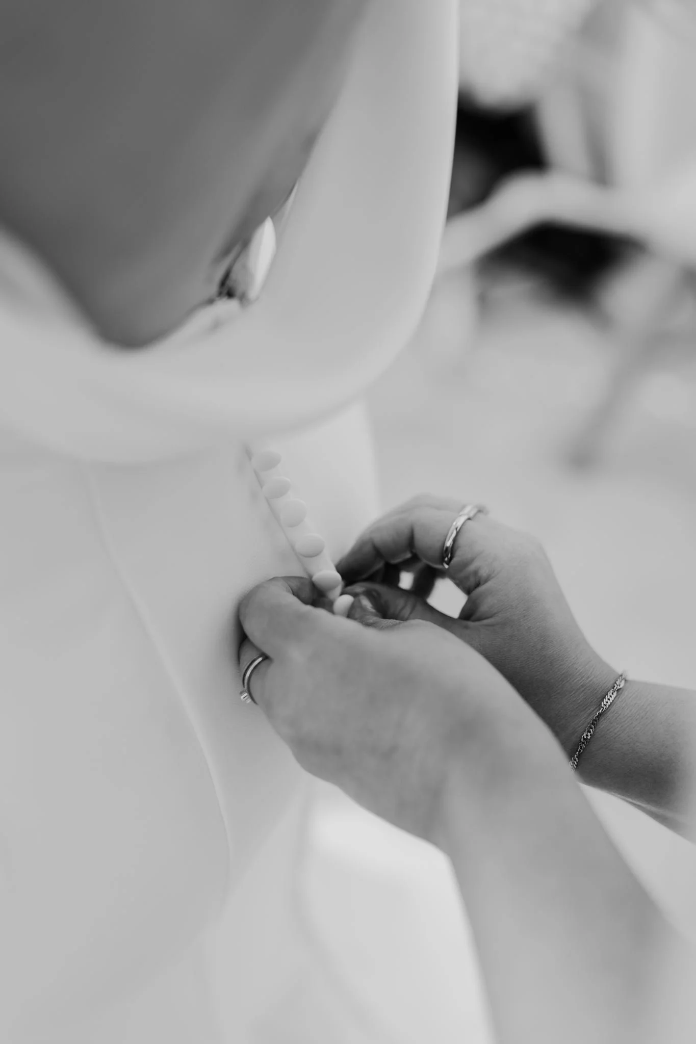 A close-up of the buttons being fastened on Rachel’s wedding dress