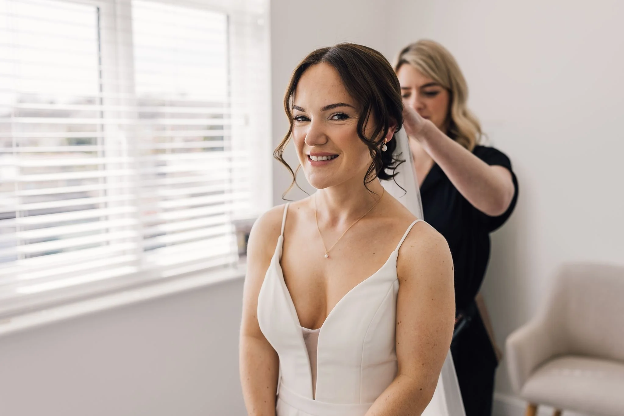Rachel smiling while her hair is adjusted before the ceremony