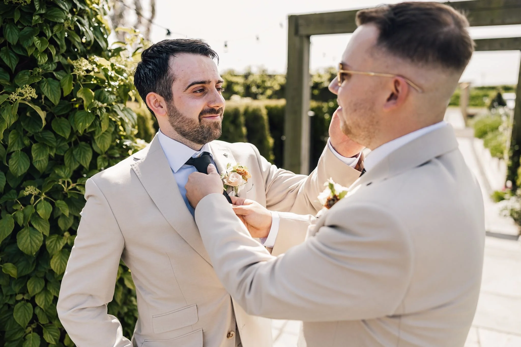Harry having his buttonhole adjusted before the outdoor ceremony
