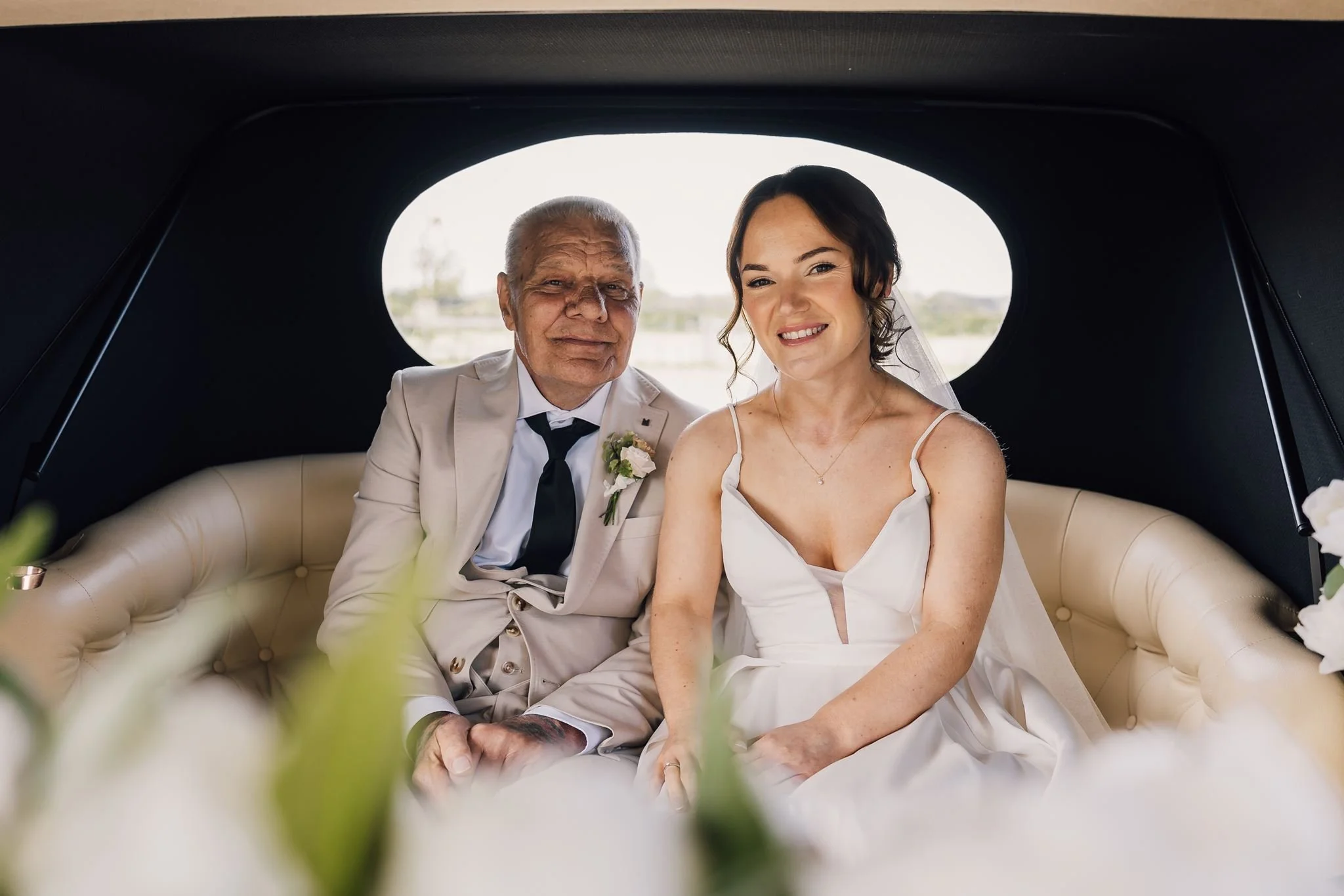 Rachel and her dad smiling together inside the wedding car