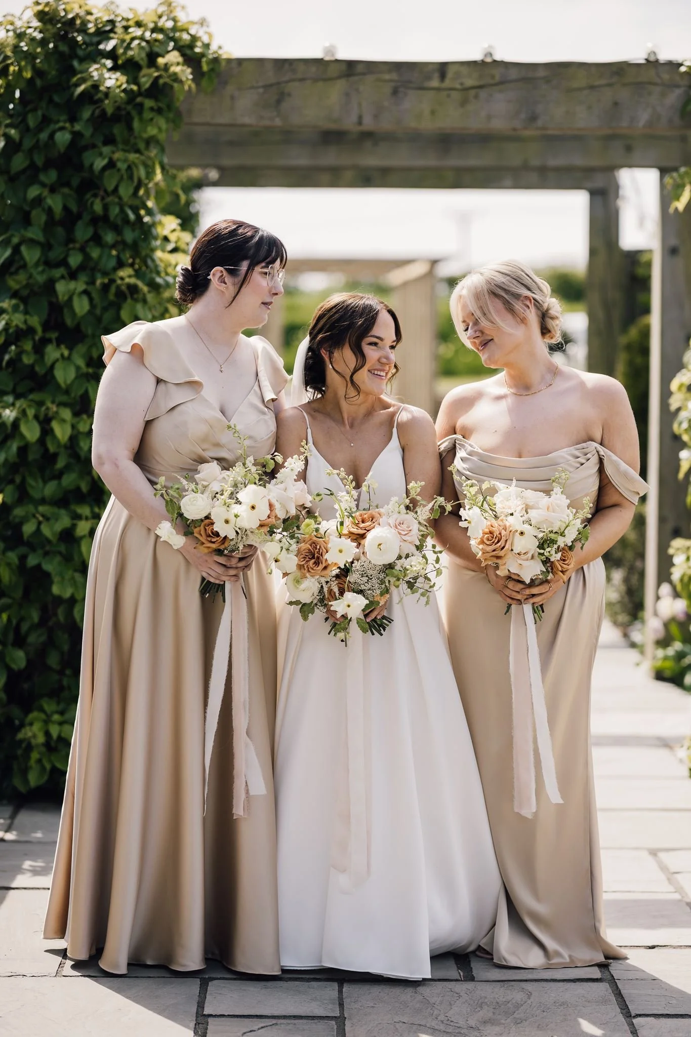 Rachel and her bridesmaids together beneath the garden pergola