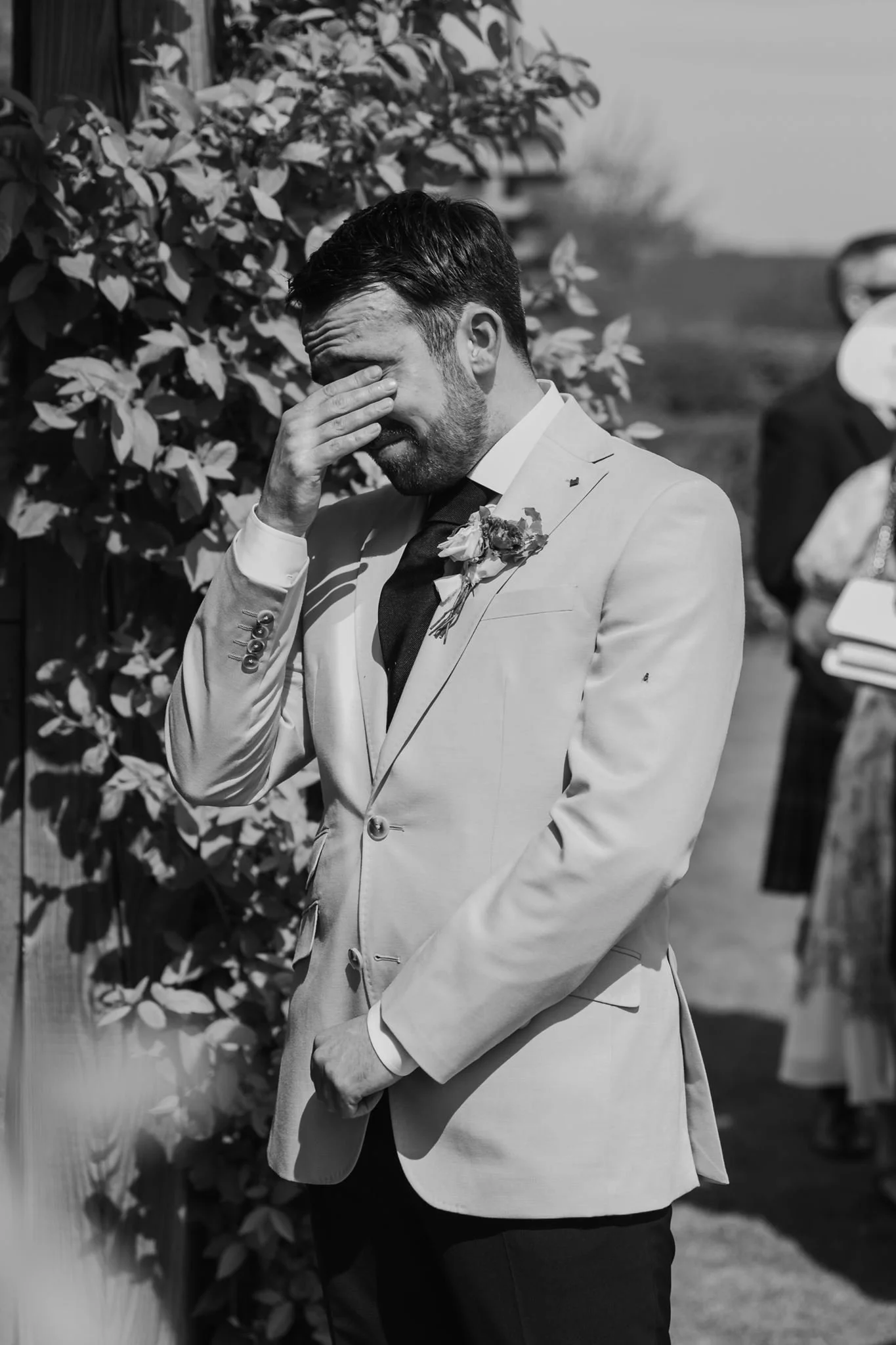 Harry wiping his eye as Rachel arrives for the ceremony, in black and white