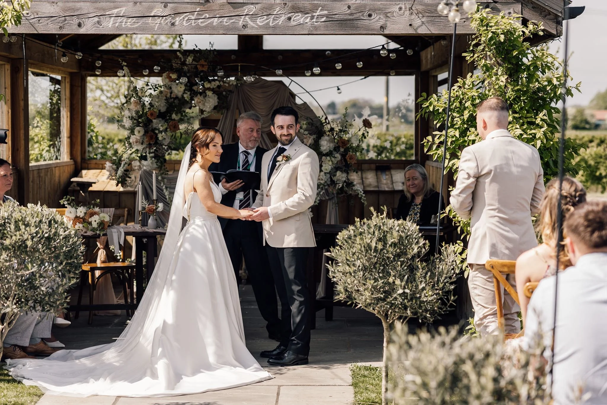 Rachel and Harry holding hands during their ceremony at The Beverley Barn