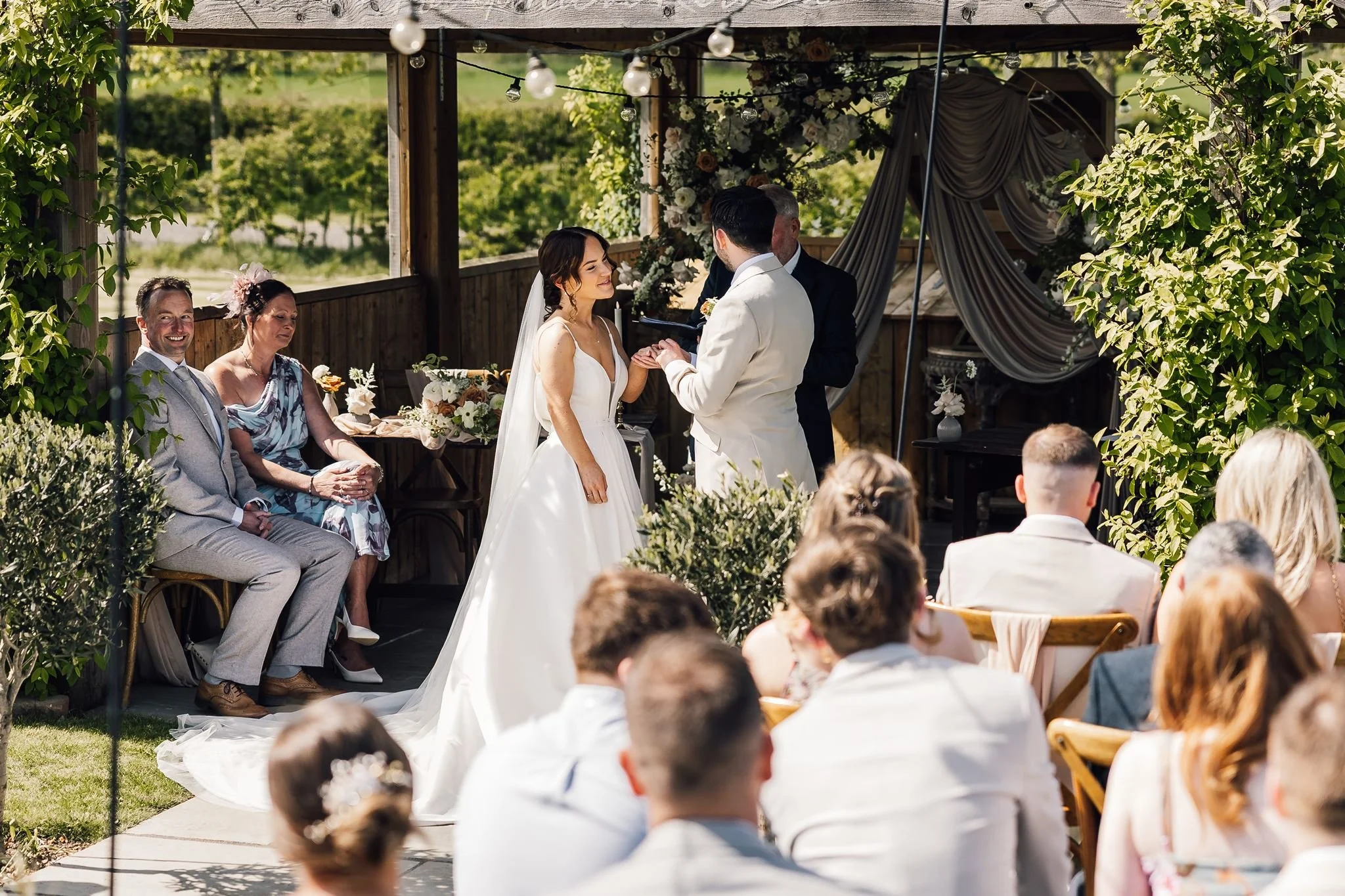 Rachel and Harry’s outdoor ceremony viewed past their seated guests